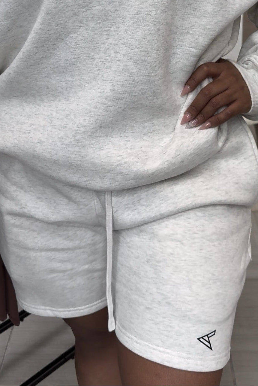 Person wearing a gray 'CURVLETICS' sweatshirt and shorts set.