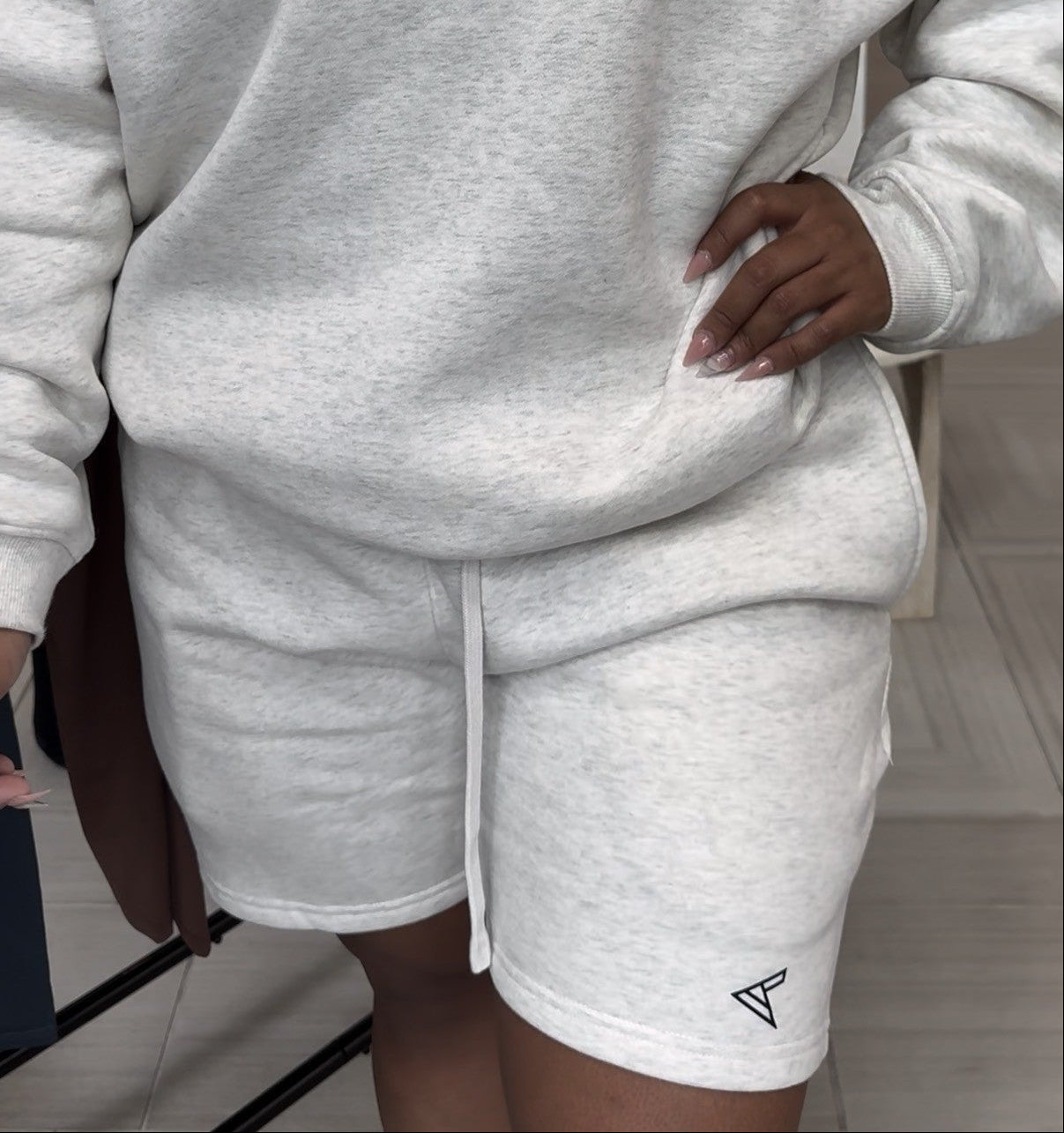 Person wearing a gray 'CURVLETICS' sweatshirt and shorts set.