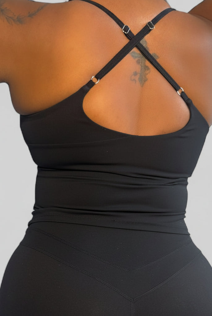 Person wearing a black athletic outfit on a plain background