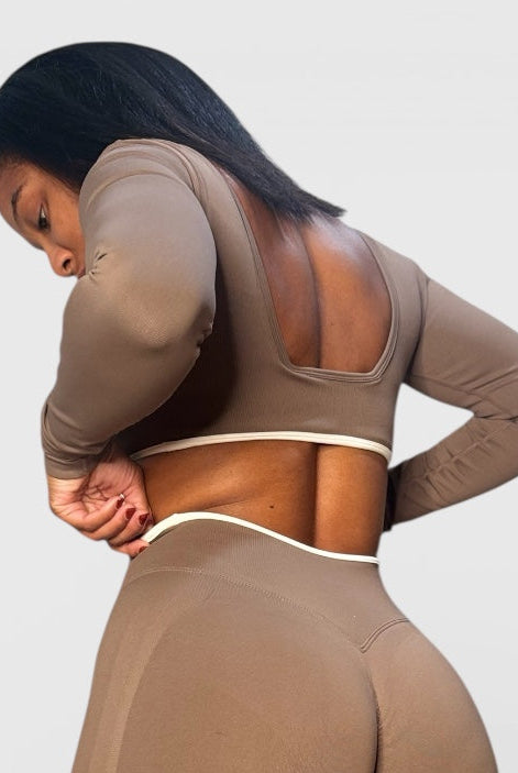 Person wearing a brown athletic outfit on a light gray background