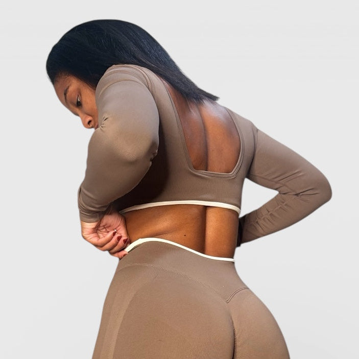 Person wearing a brown athletic outfit on a light gray background